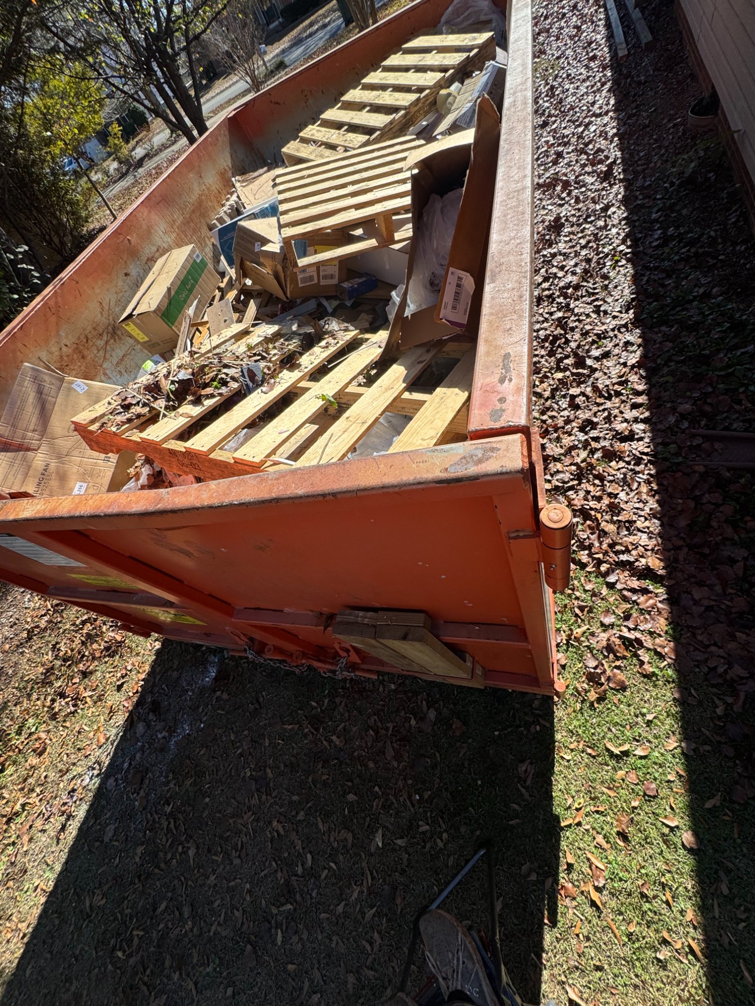 Dumpster filled with wood and pallets